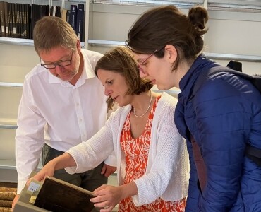 Drie personen kijken in een boek